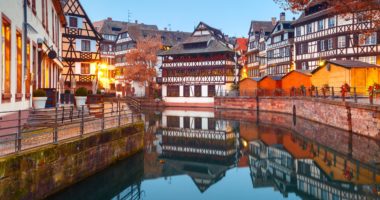Traditional Alsatian half-timbered houses in Petite France with mirror reflections during morning blue hour, Strasbourg, Alsace, France