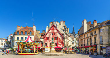 Dijon city historical centre with old typical houses colorful buildings and merry-go-round carousel on La Fontaine Place Francois Rude square, cityscape Dijon old town, Bourgogne region, France