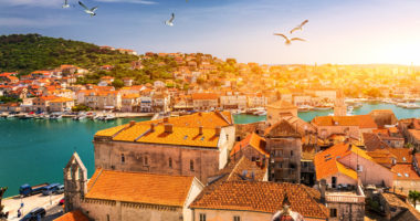 View at town Trogir, old touristic place in Croatia Europe with seagull's flying over city. Trogir town coastal view. Magnificent Trogir, Croatia. Sunny old Venetian town, Dalmatian Coast in Croatia.