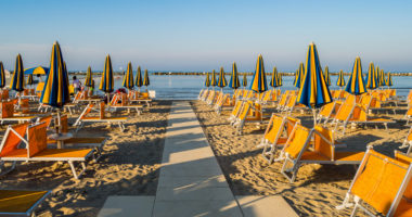 Rows of orange umbrellas and deckchairs on the beach of Igea Marina near Rimini
