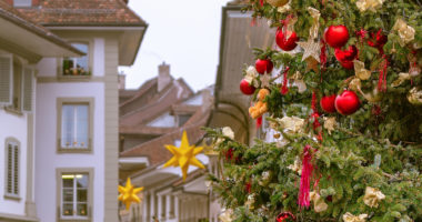 Christmas in Switzerland. Decorated Christmas tree on the background of a street in the Swiss city of Thun