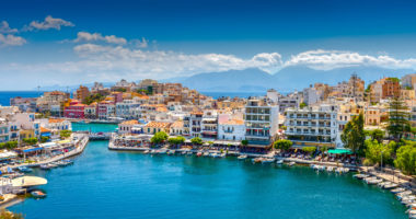 Agios Nikolaos. Agios Nikolaos is a picturesque town in the eastern part of the island Crete built on the northwest side of the peaceful bay of Mirabello.