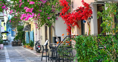 Old houses in the narrow streets of Nafplion town with Bougainvillea flowers